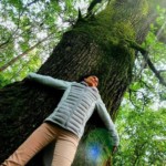 Christel Dijoux contre un arbre, pour recharger son énergie vitale.