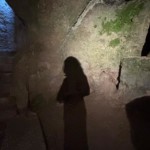 Ombre de Christel Dijoux dans une crypte souterraine, évoquant l'exploration de soi et son développement personnel.