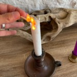 Christel Dijoux, allumant une bougie pour préparer une séance de magnétisme et d'hypnose dans son cabinet de Rimont.