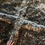 Main de Christel Dijoux, magnétiseur et praticienne en hypnose, posée sur une croix.